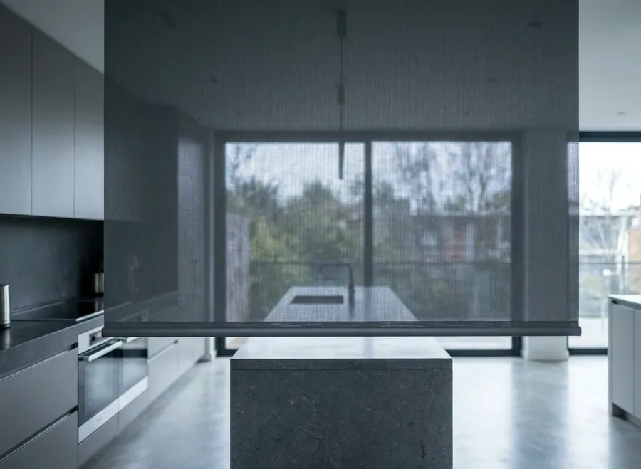 Sunscreen roller blind filtering midday light through a floor-to-ceiling glass wall in a Dunkeld family room addition